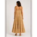 Woman wearing a beige tiered dress on a white background