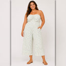 Woman wearing a strapless floral jumpsuit on a white background