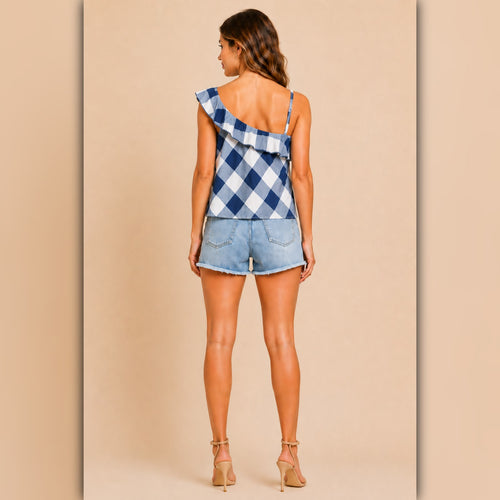 Woman wearing a blue plaid romper on a beige background
