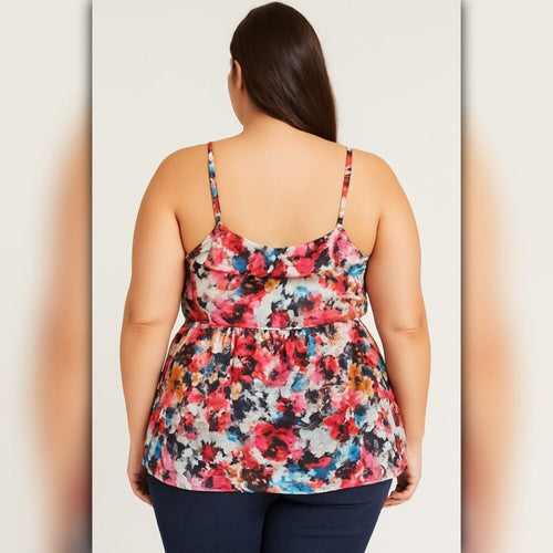 Woman wearing a colorful floral tank top on a plain background