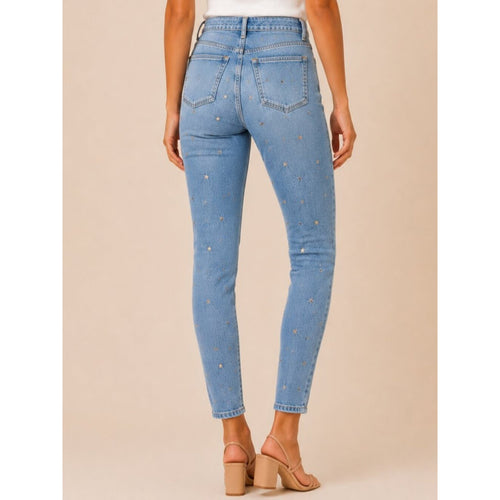 Light blue jeans with star patterns worn by a person on a beige background