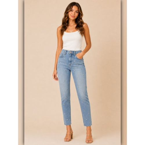 Woman wearing light blue jeans and a white top on a beige background