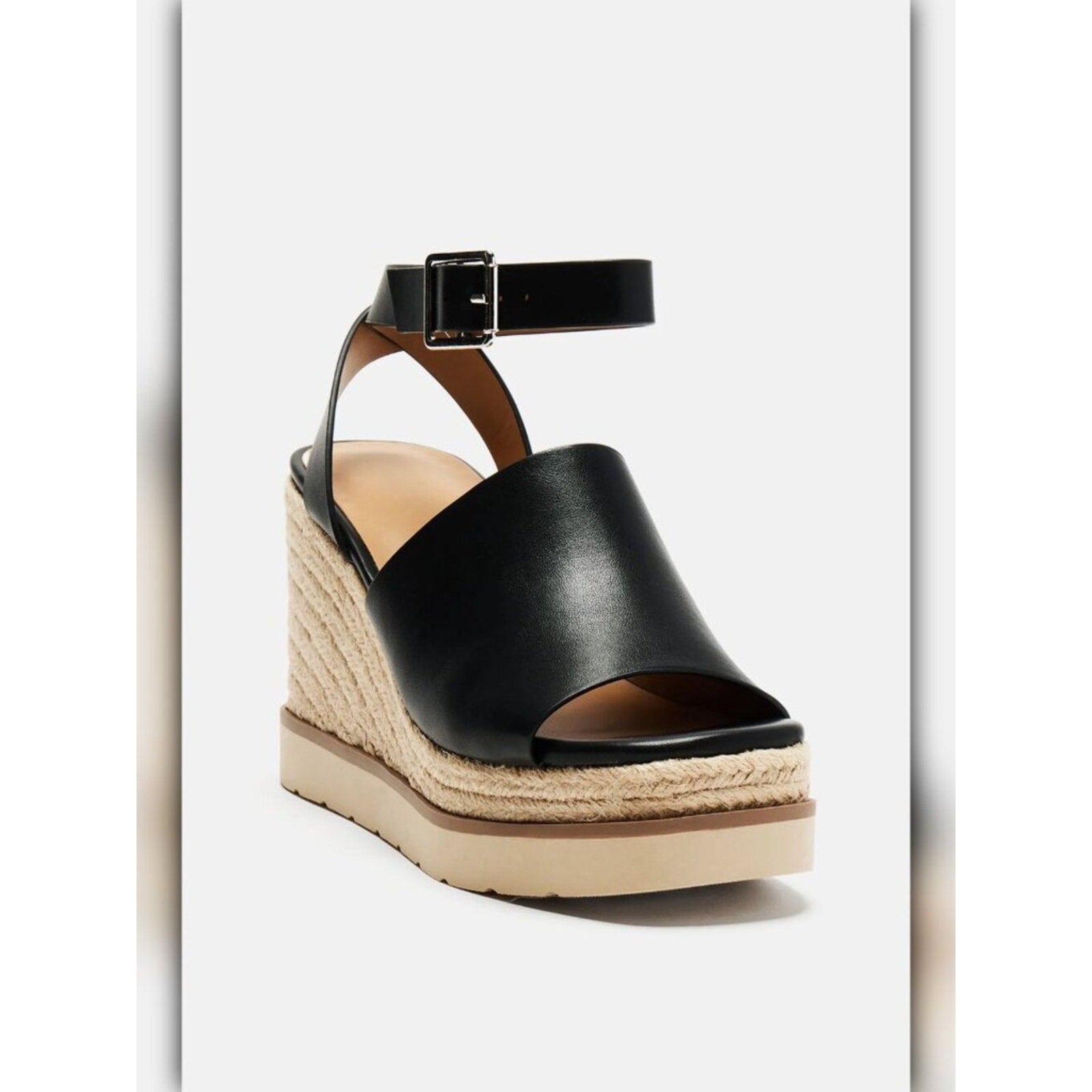 A single women's wedge sandal with a black leather peep toe, ankle strap, and braided jute platform wedge, shown on a light gray background.