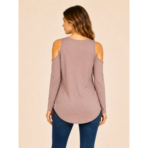 Woman wearing a mauve long-sleeve top with cold shoulder design on a beige background