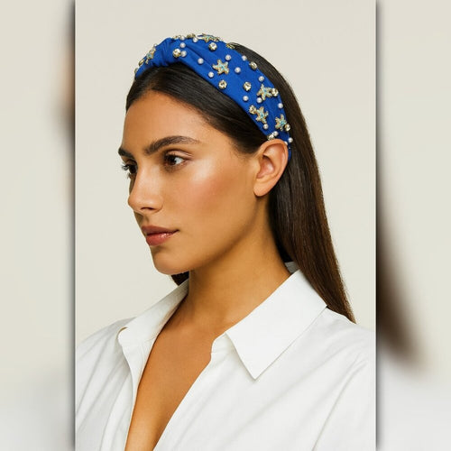 Woman wearing a blue headband with star decorations on a neutral background