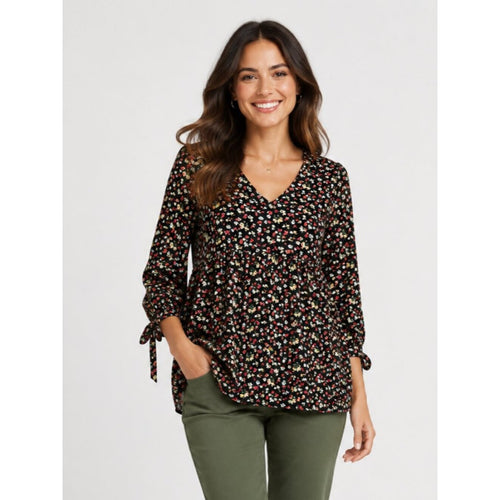 Woman wearing a floral blouse and green pants on a white background
