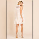 Woman wearing a white dress with lace details on a beige background
