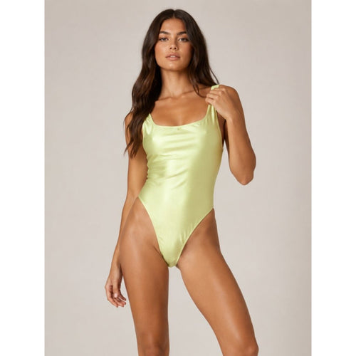 Woman wearing a light green swimsuit against a neutral background