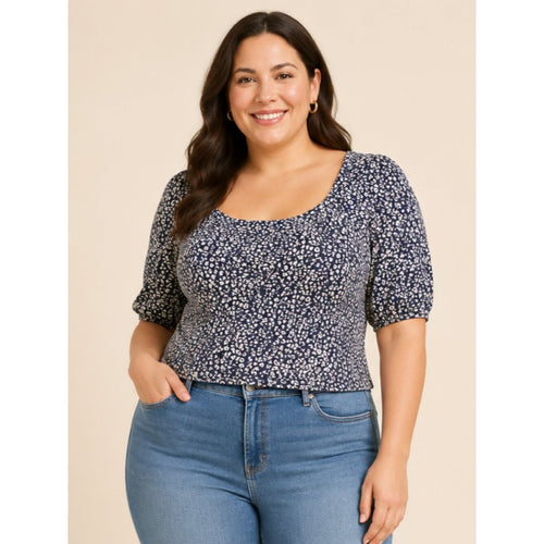 Woman wearing a floral top and blue jeans against a beige background
