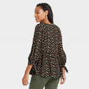 Woman wearing a floral blouse with a plain background