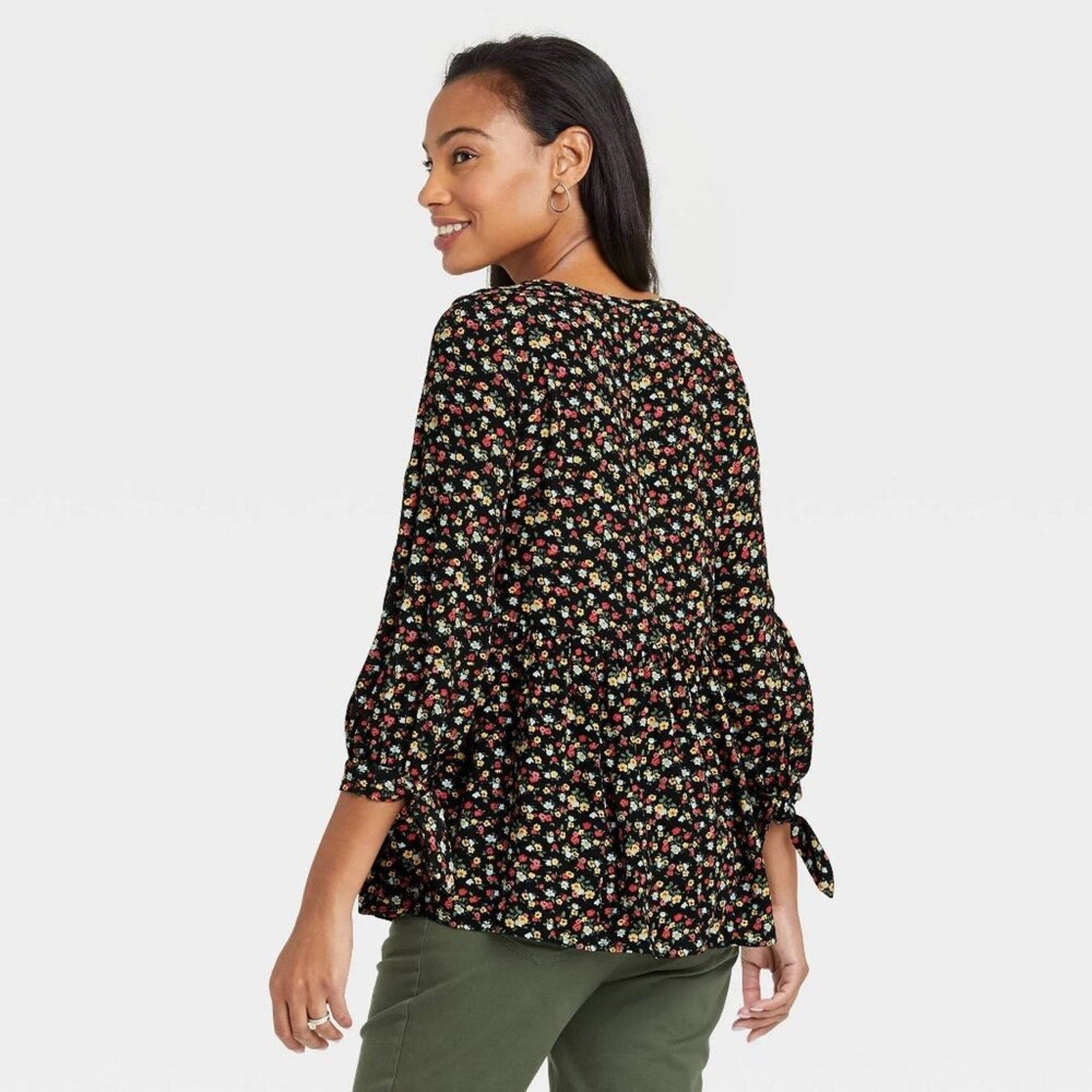 Woman wearing a floral blouse with a plain background