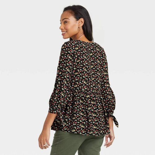 Woman wearing a floral blouse with a plain background