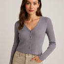 Woman wearing a gray ribbed cardigan on a beige background