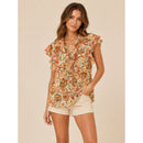 Woman wearing a floral blouse and beige shorts on a beige background