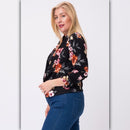 Side view of black floral open front blazer showing cropped fit, 3/4 sleeves, and curved front hem.
