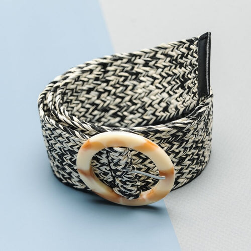 Black and white patterned belt with a decorative buckle on a light blue background
