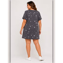 Woman wearing a dark gray t-shirt dress with white polka dots on a plain background
