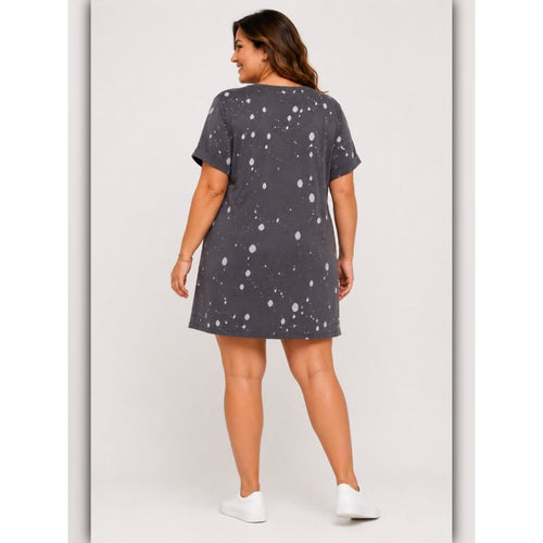 Woman wearing a dark gray t-shirt dress with white polka dots on a plain background