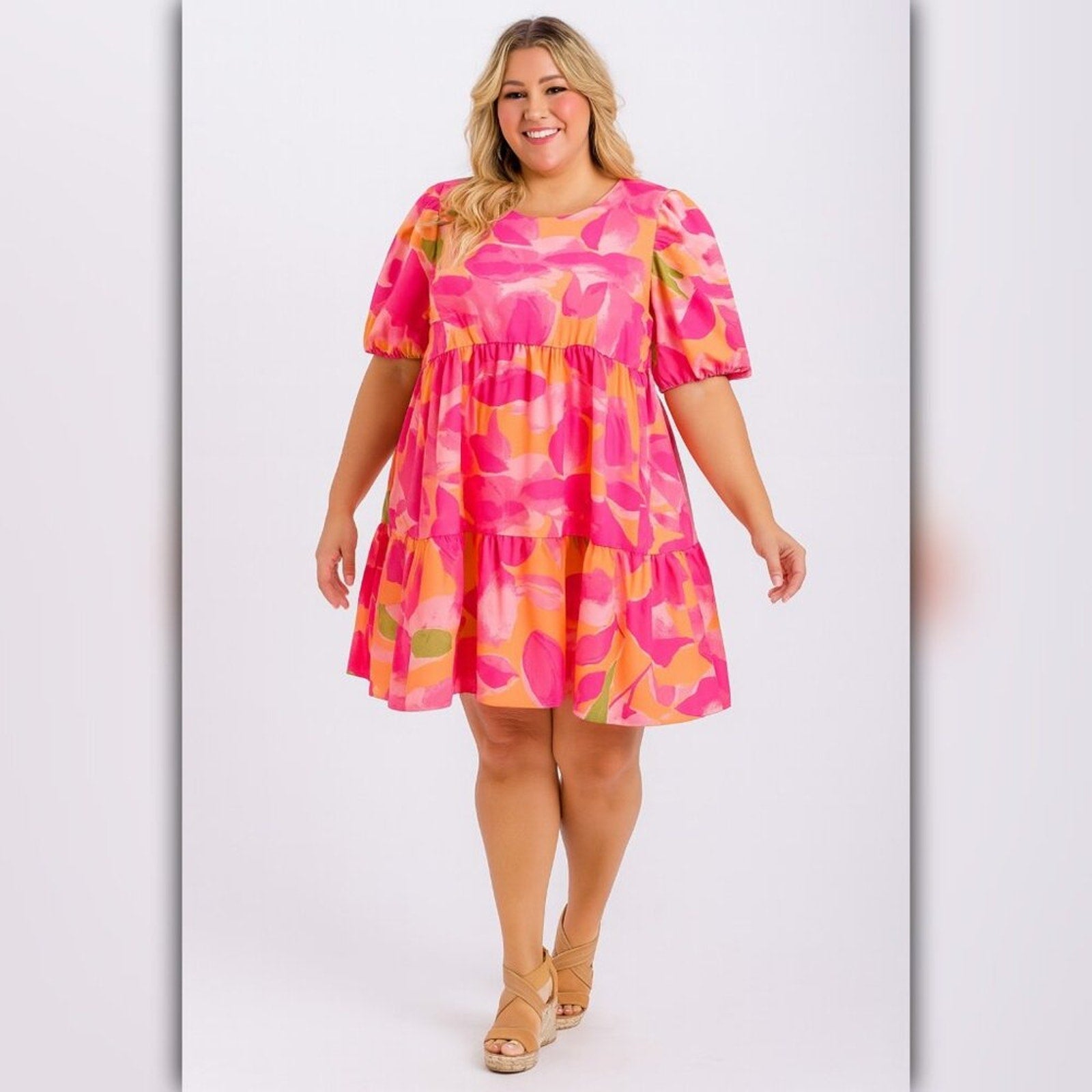 Woman wearing a pink and orange patterned dress on a white background