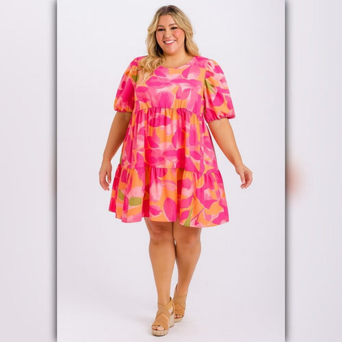 Woman wearing a pink and orange patterned dress on a white background