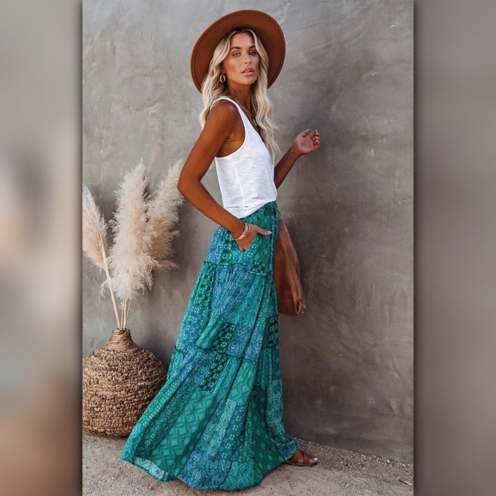 Person wearing a green patterned skirt standing against a neutral wall.