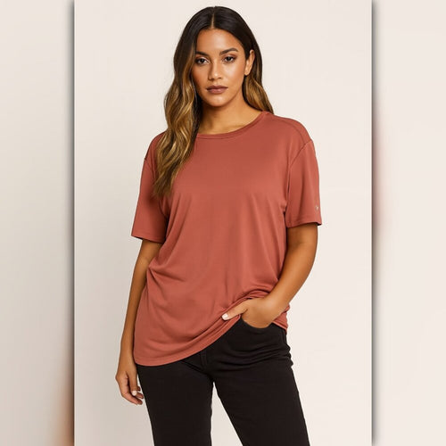 Woman wearing a rust-colored t-shirt against a beige background