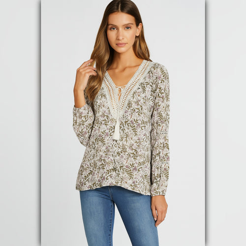 Woman wearing a floral blouse and blue jeans on a light gray background