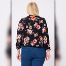 Back view of black floral blazer showing allover pink, orange, cream, and gray floral print on black fabric.