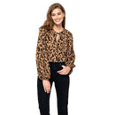 Woman wearing a leopard print blouse and black pants on a white background