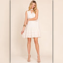 Woman wearing a white dress against a beige background