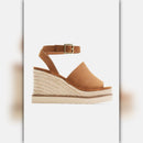 A single women's wedge sandal in tan suede and braided jute, featuring a slim ankle strap with a gold-tone buckle, shown against a light gray background.