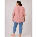 Woman wearing a pink blouse and blue pants on a plain background