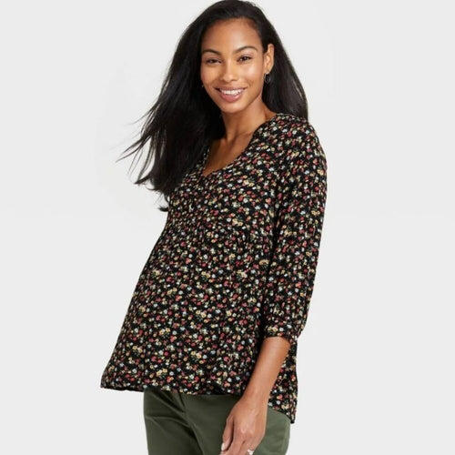 Woman wearing a floral blouse on a plain background