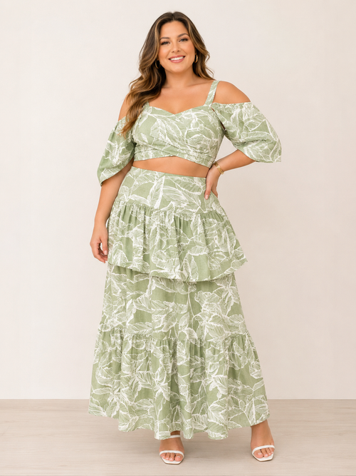 Woman wearing a green leaf-patterned two-piece outfit on a white background