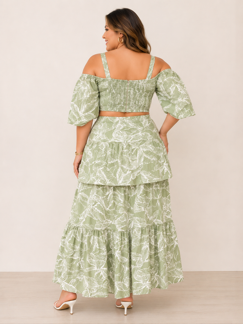 Woman wearing a green floral two-piece outfit against a beige background