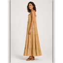 Woman wearing a beige tiered dress on a white background