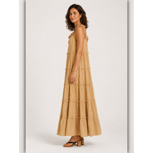 Woman wearing a beige tiered dress on a white background
