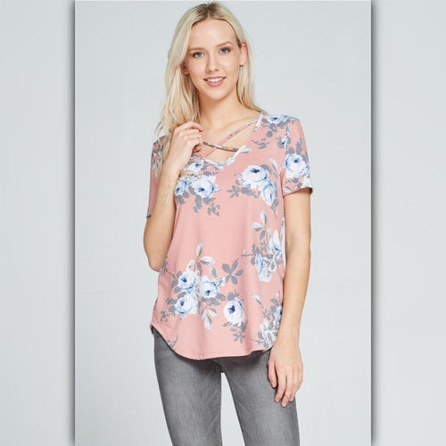 Woman wearing a pink floral blouse against a light gray background