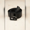 Black braided belt with a black buckle on a beige background