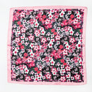 Black satin scarf with pink border featuring dense pink, white, and red floral print laid flat