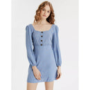 Woman wearing a blue dress with long sleeves on a white background