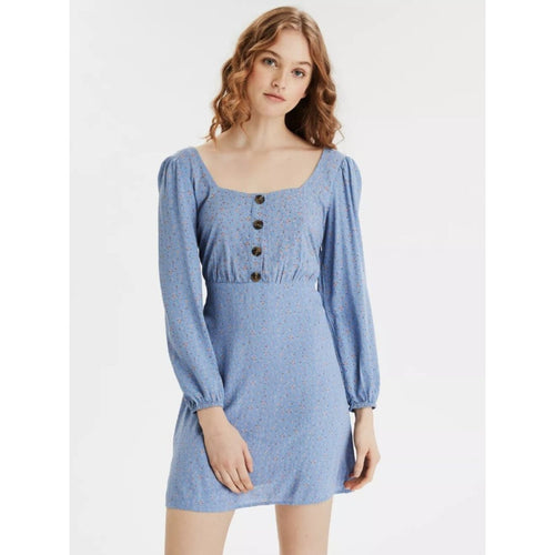 Woman wearing a blue dress with long sleeves on a white background