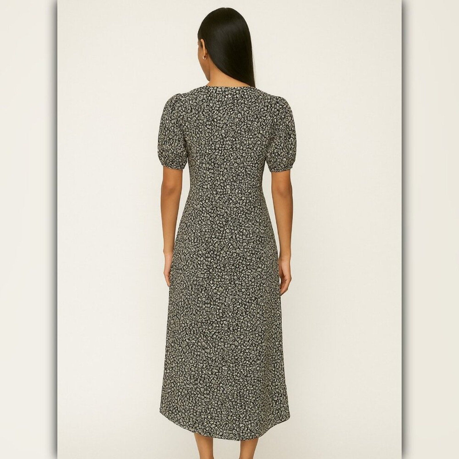 Woman wearing a patterned dress against a plain background
