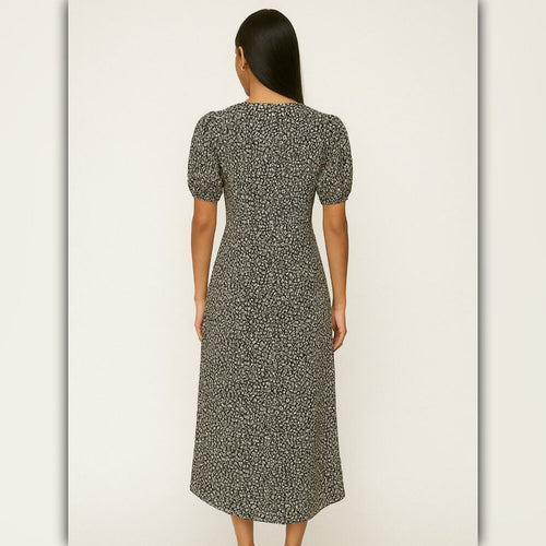 Woman wearing a patterned dress against a plain background