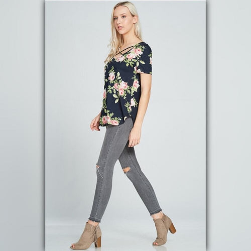 Woman wearing a floral top and gray jeans on a light gray background