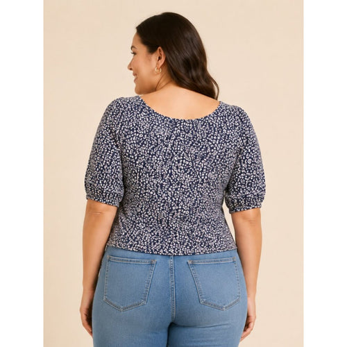 Woman wearing a blue floral top and jeans on a beige background
