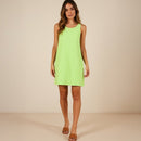 Woman wearing a bright green dress against a beige background