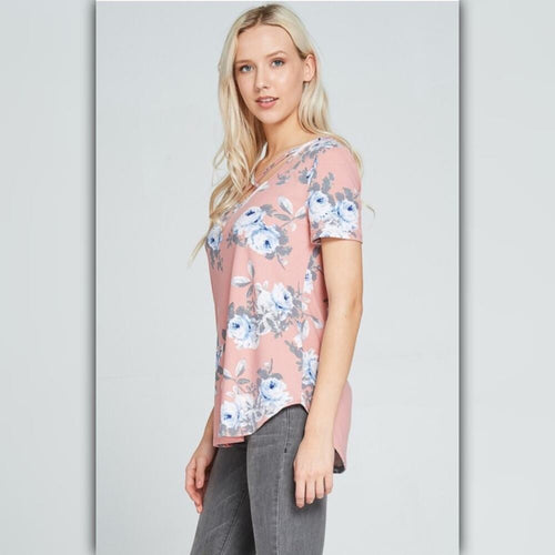 Woman wearing a pink floral top against a light gray background