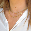 Gold chain necklace on a person wearing a white shirt