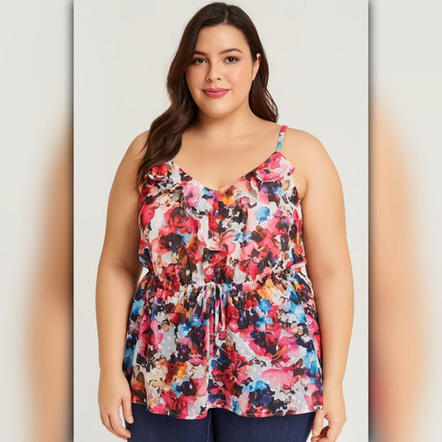Woman wearing a colorful floral tank top on a plain background